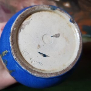 May include: Blue ceramic vase with gold accents and a white base. The base has the text "Made in Japan" printed on it.