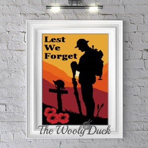 May include: A crochet pattern featuring a silhouette of a soldier standing at a grave with a poppy flower and the words "Lest We Forget".