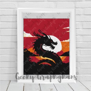May include: Framed pixel art print depicting a black dragon against a red and orange sunset sky with a large white moon. The print is in a white frame and has the text "Geeky Graphghans" at the bottom.