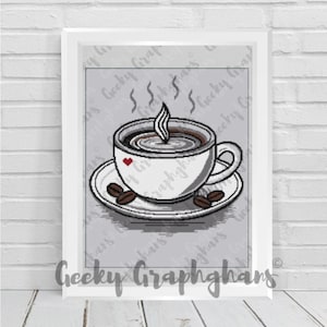 May include: Framed print with a pixelated coffee cup illustration. The white cup, with a red heart, sits on a saucer with coffee beans. Steam rises from the coffee. The background is grey with the text "Geeky Graphghans".