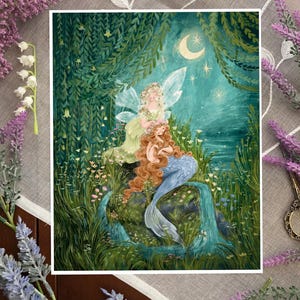 May include: A painting of a mermaid with long red hair sitting on a rock with a fairy with wings and a flower crown. The scene is set in a lush green forest with a moon and stars in the night sky.