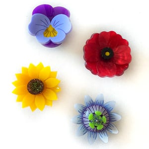 Könnte beinhalten: Ein Set aus drei Keramikbechern mit gesprenkelter, matter Oberfläche. Die Becher sind in Creme-, Hellgrau- und Dunkelgrautönen gehalten. Jeder Becher hat ein schlichtes, minimalistisches Design.