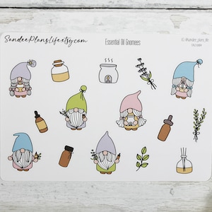 Könnte beinhalten: Eine Bogen mit Aufklebern, die Gnome, ätherische Ölflaschen und andere Illustrationen zum Thema Aromatherapie zeigen. Die Aufkleber sind weiß mit schwarzen Umrissen und in verschiedenen Farben gehalten, darunter Rosa, Blau, Grün und Lila. Der Text "Essential Oil Gnomes" ist oben auf dem Bogen gedruckt.