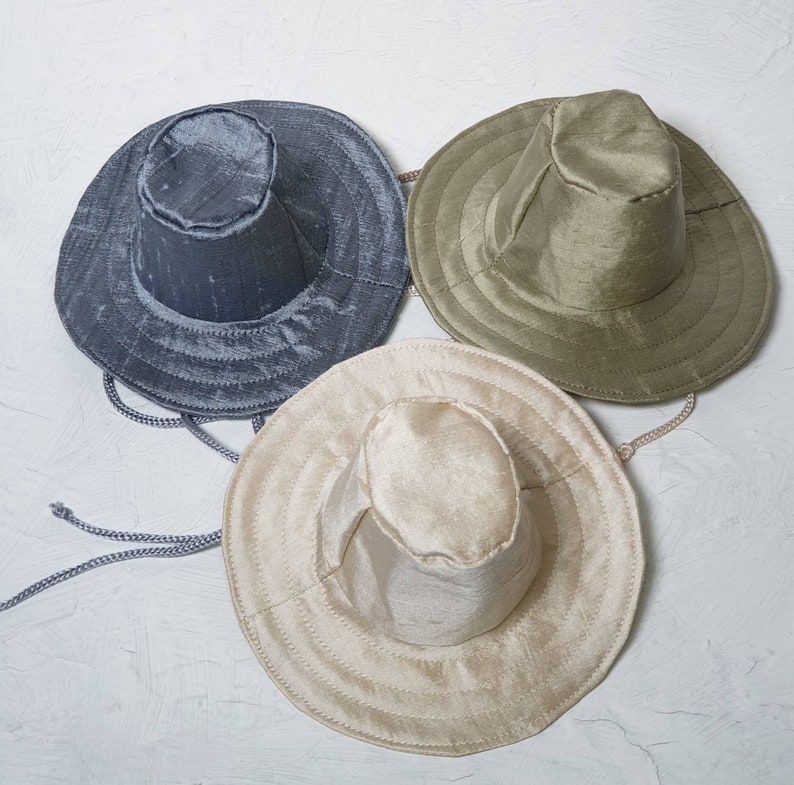 Puede incluir: Tres sombreros de ala ancha en diferentes colores. Los sombreros est&aacute;n hechos de una tela suave y texturizada. Los sombreros est&aacute;n todos enfocados y est&aacute;n dispuestos en forma triangular.