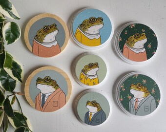 Small paintings of toads wearing clothes