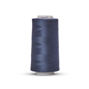 May include: A spool of dark blue sewing thread with the brand name "keedli" printed on the label.