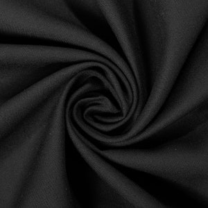 May include: Close-up of a black fabric with a smooth, even texture. The fabric is folded and twisted, creating a swirling pattern.