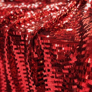 May include: Red sequin fabric with a square pattern. The sequins are shiny and reflect light.