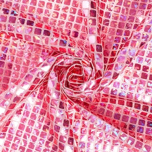 Könnte beinhalten: Pinkfarbener, schimmernder Stoff mit quadratischem Muster. Der Stoff ist in der Mitte zusammengezogen und erzeugt so einen wirbelnden Effekt.