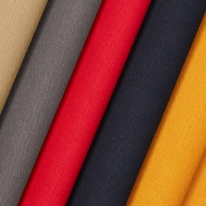 Puede incluir: Primer plano de muestras de tela dobladas en varios colores: beige, gris, rojo, azul marino y amarillo. La tela presenta un sutil patrón de tejido diagonal, lo que sugiere un material duradero adecuado para ropa o tapicería.