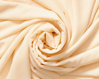 May include: A close-up of a swirl of soft, pale beige fabric. The fabric is smooth and has a subtle texture.