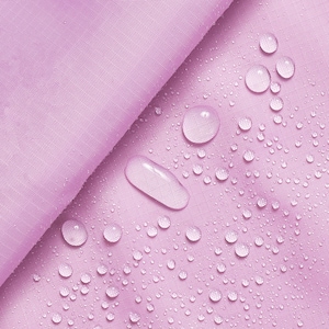 Pode incluir: Close-up de um tecido rosa claro com gotas de água na superfície. O tecido é liso e tem um brilho sutil.