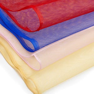 May include: Close-up of layered, sheer fabric in red, blue, pink, and yellow. The fabric has a fine mesh texture, with the edges of each layer rolled and sewn. The colours are vibrant and the fabric appears lightweight, suitable for various craft projects.