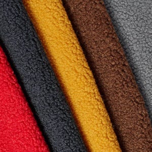 Puede incluir: Primer plano de varias muestras de tela texturizada en varios colores. Los colores incluyen rojo, gris oscuro, amarillo dorado, marrón y gris. La tela tiene un aspecto suave y afelpado.