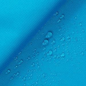 May include: Close-up of a blue fabric with water droplets on the surface. The fabric is folded in half, creating a diagonal line across the image.
