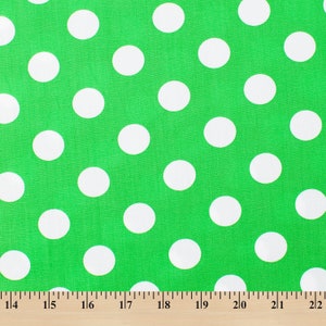 May include: Green fabric with white polka dots. The fabric is measured with a ruler in inches.