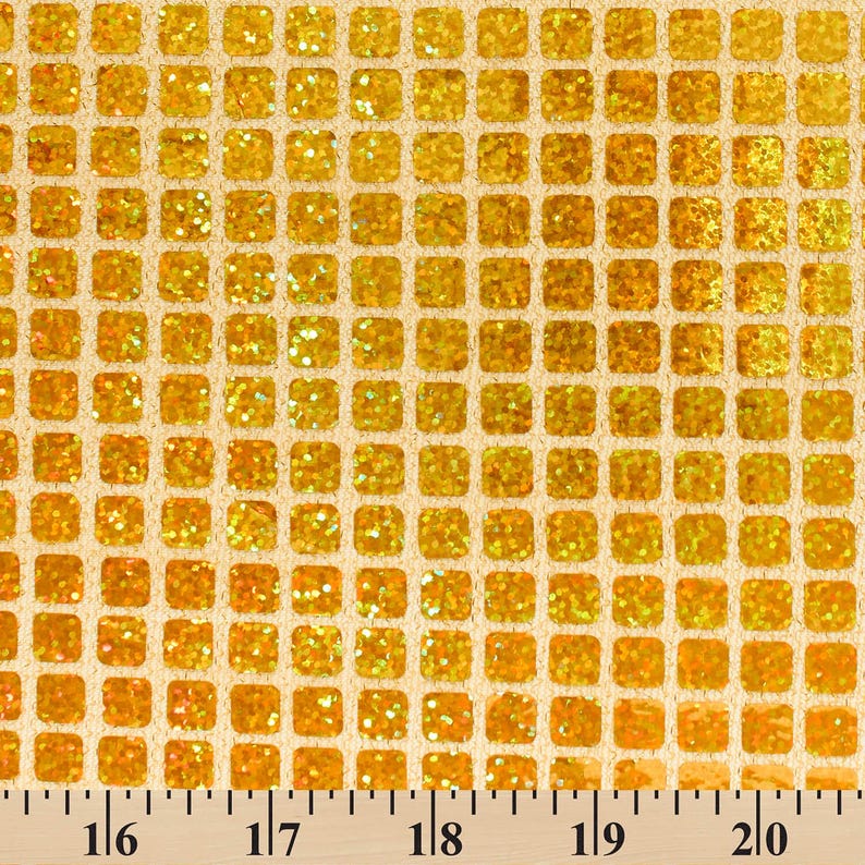 May include: Gold glitter fabric with a square grid pattern. The fabric is measured in inches.