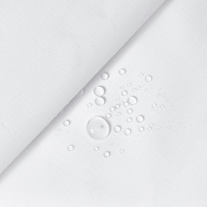 Può includere: Tessuto bianco con numerose gocce d'acqua sulla superficie. Il tessuto è liscio e sembra essere impermeabile.