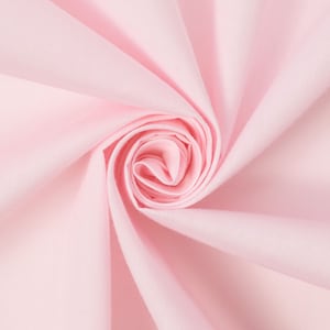 May include: A close-up of a soft, pink fabric swirled into a rose shape. The fabric is smooth and has a subtle sheen.