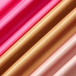May include: Close-up of four diagonal fabric swatches in shades of pink and gold. The fabrics have a subtle striped pattern and a shiny, silky texture. The colors range from deep fuchsia to pale blush and golden tan.