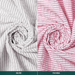 May include: Two fabric samples, one silver and one fuchsia, both with a striped pattern. The silver fabric has grey and white stripes, while the fuchsia fabric has red and white stripes. The fabrics are arranged in a spiral.