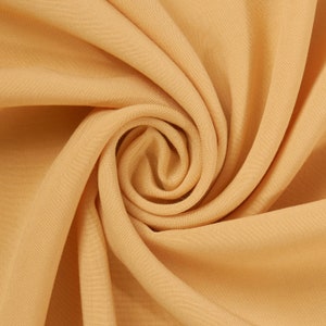 May include: A close-up of a soft, smooth, and light yellow fabric with a swirling pattern.