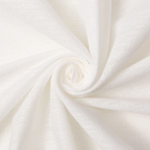 May include: Close-up of a white fabric with a smooth, even texture. The fabric is folded and twisted into a spiral shape, creating a soft, flowing effect.