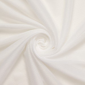 May include: White fabric with a soft, smooth texture, draped and folded to create a swirling pattern.