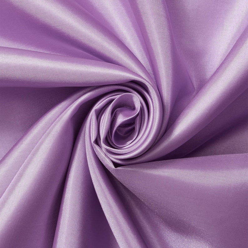 May include: A close-up of a soft, smooth, lilac-colored fabric with a swirling, rose-like pattern.