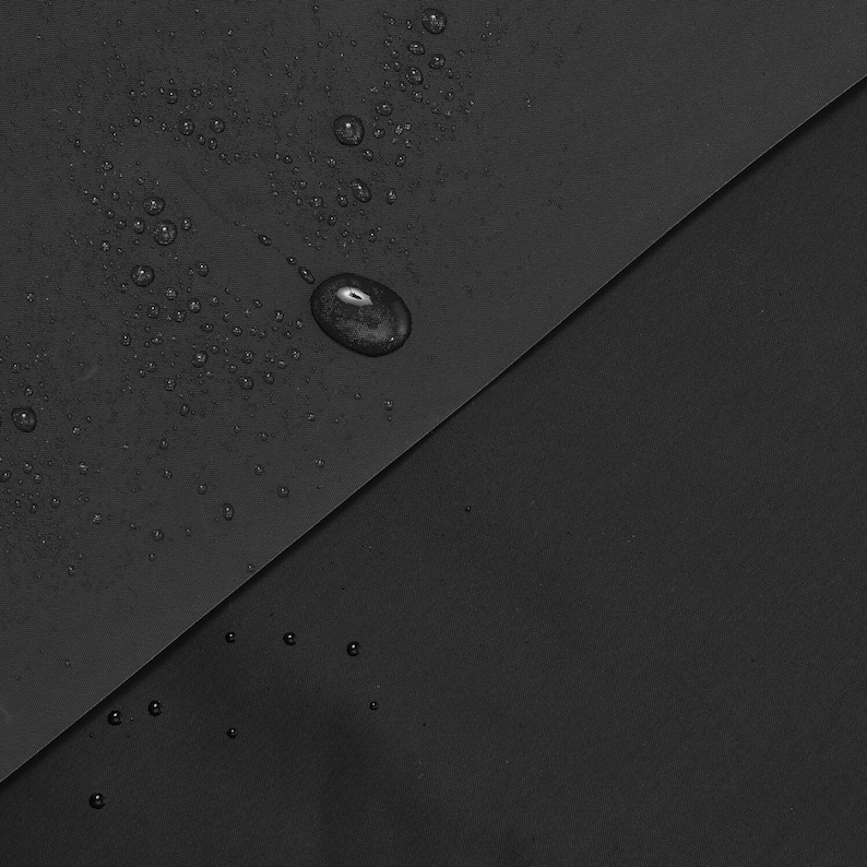 May include: A close-up of a black fabric with water droplets on the surface. The fabric is folded in half, creating a diagonal line.