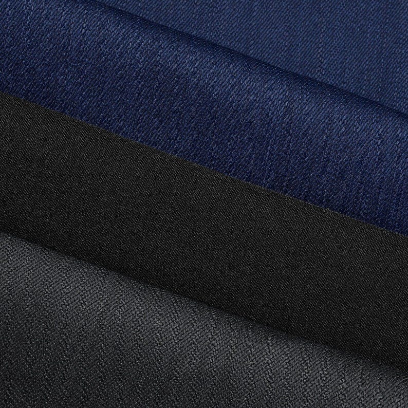 May include: Close-up of three different fabric swatches. The top swatch is a deep navy blue, the middle is black, and the bottom is a dark gray. All three fabrics have a subtle woven texture, with visible diagonal lines.