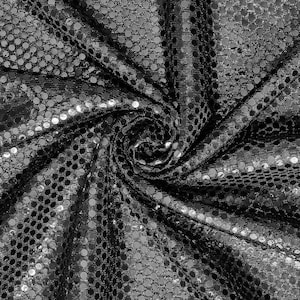 Puede incluir: Tela negra con lentejuelas plateadas en un patrón circular. La tela está recogida y retorcida, creando un efecto de remolino.