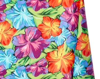 May include: Vibrant fabric featuring a tropical floral pattern. Large hibiscus flowers in shades of orange, red, purple, and blue are set against a light green background with green leaves. The fabric is likely used for clothing or home decor.