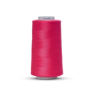 May include: A spool of pink sewing thread with the word "keedll" printed on the label.