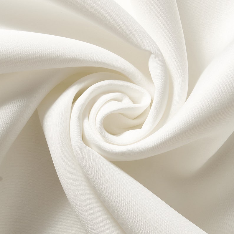 Puede incluir: Primer plano de un remolino de tela blanquecina. La tela es suave y parece ser seda o un material similar. Los pliegues crean un patr&oacute;n en espiral, siendo el centro del remolino el punto focal.