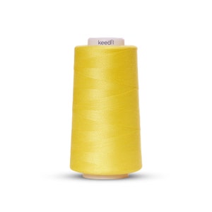 May include: A spool of bright yellow thread with the word "keedll" printed on the label.