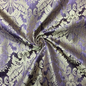 Pode incluir: Tecido roxo com um padr&atilde;o de damasco dourado. O tecido &eacute; tecido com uma textura sutil e tem uma sensa&ccedil;&atilde;o luxuosa.