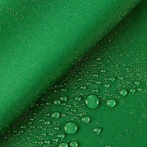 Può includere: Tessuto verde con una superficie strutturata. Gocce d'acqua sparse sul tessuto.
