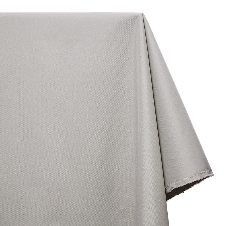 May include: A plain, light gray fabric tablecloth with a slightly rough texture.
