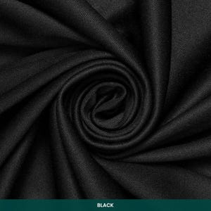 K&ouml;nnte beinhalten: Ein einfarbiger schwarzer Stoff mit sichtbarer Webstruktur, der in einem zentralen Spiralmuster angeordnet ist. Das Material weist tiefe Falten und Schatten auf, die die gleichm&auml;&szlig;ige dunkle Farbe und das komplexe Gewebe hervorheben.