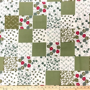 May include: A green and white fabric with a patchwork design featuring various floral patterns. The fabric has a checkered pattern with squares of solid green and squares with a white background and small green floral designs. Some squares have larger red and green floral designs.