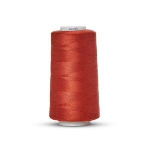May include: A spool of orange thread with the word "keedli" printed on the label.