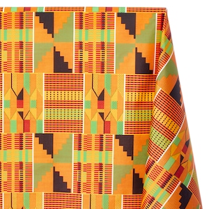 Pode incluir: Um close-up de um tecido com um padrão geométrico colorido. O padrão é composto por quadrados e retângulos em tons de laranja, amarelo, verde, vermelho e preto. O tecido está dobrado no canto superior direito.