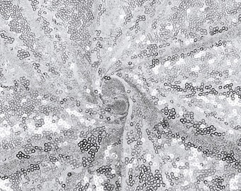 May include: Silver sequin fabric with a swirling pattern. The sequins are small and tightly packed, creating a shimmering effect.