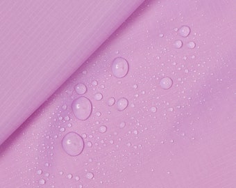 May include: A close-up of a light purple fabric with water droplets on the surface. The fabric has a subtle texture and appears to be water-resistant.