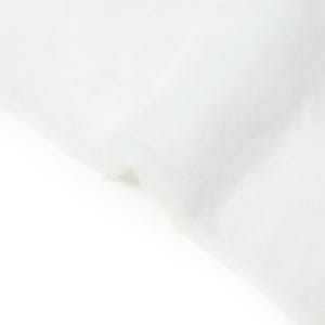 Può includere: Un pezzo di materiale bianco, morbido, soffice e fibroso con una consistenza densa simile a una nuvola. La superficie appare uniforme e opaca, mostrando una piega delicata che crea ombre e riflessi sottili sul tessuto fibroso bianco.
