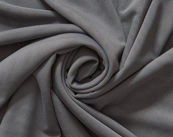 May include: Close-up of a gray fabric with a textured, woven pattern. The fabric is folded and twisted into a spiral shape.