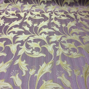 May include: Purple fabric with a gold floral pattern. The pattern features stylized leaves and flowers.