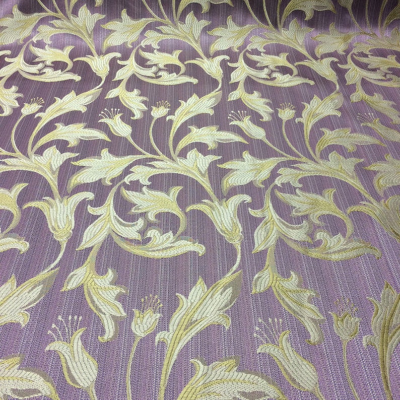May include: Purple fabric with a gold floral pattern. The pattern features stylized leaves and flowers.