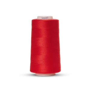 May include: A spool of red thread with the word "keedli" printed on the label.
